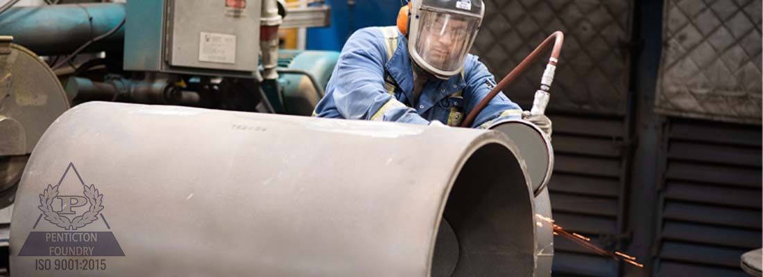 An employee at Penticton Foundry working on a pipe.